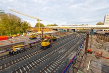 Door de blauwe en rode buizen lopen de kabels die normaal onder het spoor liggen. We hangen deze kabels van het spoor nu in de lucht zodat ze niet beschadigen tijdens de werkzaamheden en het inrijden van het spoordek.